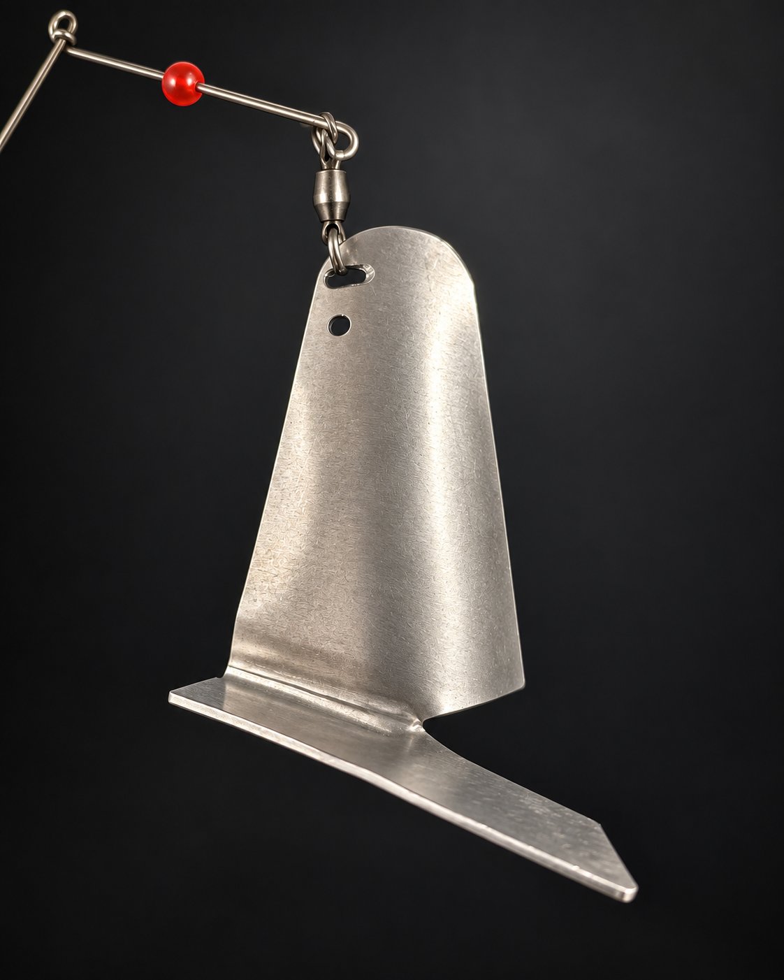Studio close-up of the Kitchen Sink folded metal blade, its mounting holes and swivel.